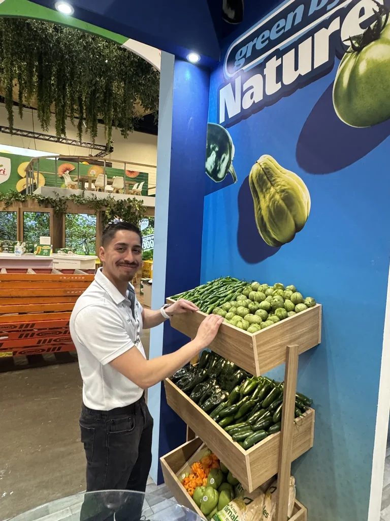 SiCar Farms team member arranging produce at the booth